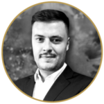 Black and white portrait of Richan Schwellnus, a smiling young man in a suit.